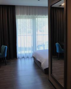- une chambre avec un lit et un grand miroir dans l'établissement TITA Family House, à Gnedin
