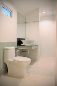 ein Badezimmer mit einem weißen WC und einem Waschbecken in der Unterkunft Homey Dormy Chiangrai in Chiang Rai