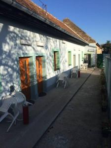 a white house with chairs and a building at Apartments Avram in Vršac