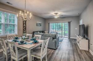una sala de estar con una mesa y un sofá en Pool and Golf Course Access North Myrtle Beach Gem, en North Myrtle Beach