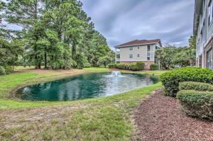 una casa con un estanque frente a una casa en Pool and Golf Course Access North Myrtle Beach Gem, en North Myrtle Beach