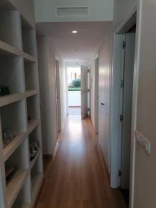 un long couloir avec des étagères blanches dans un appartement dans l'établissement Gimena playa, à Vera