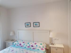 ein Schlafzimmer mit einem Bett und zwei Bildern an der Wand in der Unterkunft Gimena playa in Vera