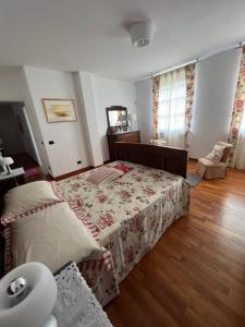 1 dormitorio con 1 cama con colcha de flores en MyVilla B&B, en Palazzo Canavese