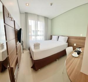 a hotel room with a large bed and a table at Express Vieiralves in Manaus