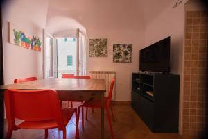 a dining room with a wooden table and red chairs at Il Nido di Arianna nel centro di Loano in Loano +12 photos
