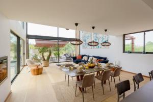 uma sala de jantar e sala de estar com mesa e cadeiras em Troya Regal Villa by CadenzaLux em Tróia