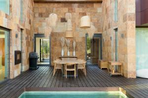 un patio con tavolo e sedie e una piscina di Troya Regal Villa by CadenzaLux a Tróia