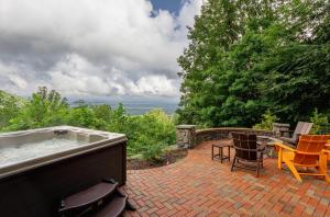 a hot tub on a patio with chairs and a table at Mountain View Sanctuary in Weaverville