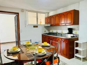 a kitchen with a table with yellow dishes on it at Santa Marta Apartamentos - Palanoa in Santa Marta