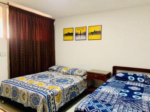 1 dormitorio con 2 camas, mesa y 2 posters en Santa Marta Apartamentos - Palanoa, en Santa Marta