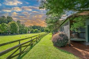 uma casa com uma cerca ao lado de um campo em Buttercup Cottage em Asheville