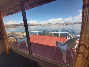 eine Terrasse mit 2 Stühlen und einem Tisch auf einem Boot in der Unterkunft Titicaca Utama Lodge Perú in Puno