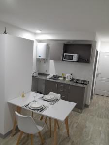 una pequeña cocina con mesa blanca y sillas en París 1 Monoambiente en Rosario