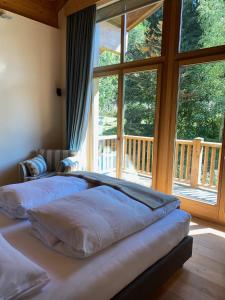 a bedroom with two beds in front of a large window at ClubHotel Hinterthal Am FlorySee 12 in Hinterthal
