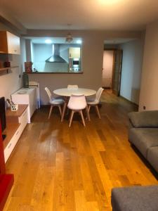 a kitchen and a living room with a table and chairs at Precioso apartamento con piscina, ideal familias! in Sort