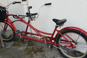 a red bike parked next to a white wall at TRANKIL' appart in Sévrier