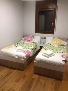 2 Einzelbetten in einem Zimmer mit Spiegel in der Unterkunft Precioso apartamento con piscina, ideal familias! in Sort