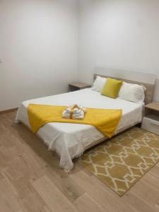 um quarto com uma cama com um cobertor amarelo em IPB Studios em Bragança