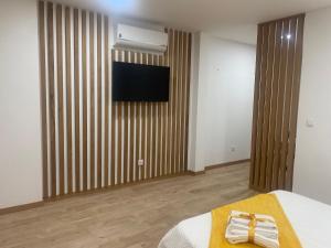 um quarto de hotel com uma televisão na parede em IPB Studios em Bragança