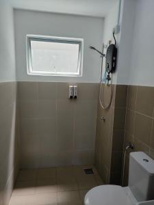 een badkamer met een toilet en een raam bij Sutra Damai Seaview in Kuantan