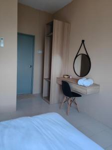- une chambre dotée d'un bureau avec un miroir et une chaise dans l'établissement Sutra Damai Seaview, à Kuantan