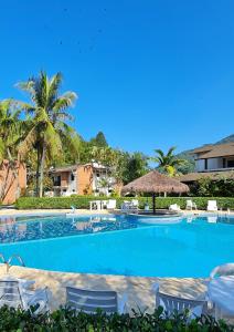 uma grande piscina com cadeiras e palmeiras em Casa Melo 4 em Ubatuba