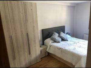 um quarto com uma cama e um grande armário de madeira em Precioso apartamento con piscina, ideal familias! em Sort