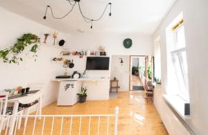 cocina y sala de estar con paredes blancas y suelo de madera. en White Lodge - central beach apartment, en Liepāja