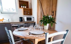 eine Küche mit einem Holztisch und Stühlen drumherum. in der Unterkunft Cab’âne in Guémar