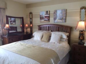 a bedroom with a large bed with white sheets and pillows at Lurgan West Lodge in Randalstown