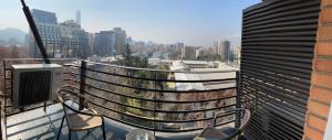 a balcony with a television and a view of a city at Brizen Apartments in Santiago
