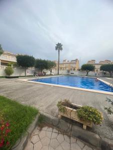 a large swimming pool in a courtyard with buildings at Calle canarias in Gran Alacant
