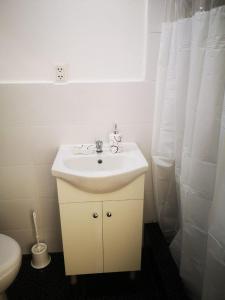een badkamer met een witte wastafel en een toilet bij Cabañas Killari in Oxapampa