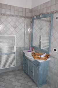 ベッラーリア・イジェア・マリーナにあるVilletta BBBのバスルーム(青いシンク、鏡付)