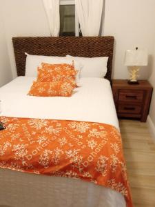 a bedroom with a bed with an orange blanket at 5 Bay's of Pirates Bahamas Great Harbour Cay, Bahamas in Bullocks Harbour