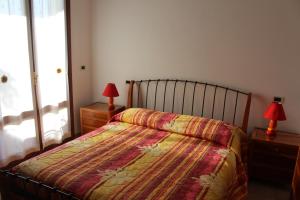 ベッラーリア・イジェア・マリーナにあるVilletta BBBのベッドルーム1室(ベッド1台、ナイトスタンドのランプ2つ付)
