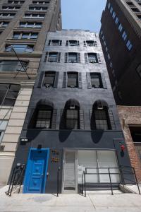a building with a blue door and two tall buildings at The Flat NYC in New York