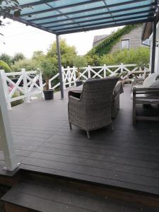 a wooden deck with a chair and an umbrella at Les studios du Domaine d'Eva in Libramont