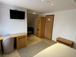 a room with a bed and a television on the wall at Rada Guest House in Plitvička Jezera