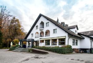 ein weißes Haus mit schwarzem Dach in der Unterkunft Hotel Thorenberg in Luzern