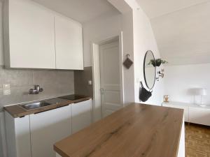 uma cozinha com armários brancos e uma mesa de madeira em Studio Tara with balcony em Bled