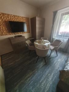 sala de estar con bañera, sillas y TV en Harmony apartments en Mórahalom