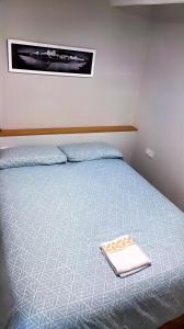 um quarto com uma cama com um livro em Precioso estudio en Cedeira. em Cedeira