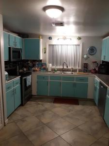 a kitchen with blue cabinets and a sink at Nana's Cheerful cottage in Melbourne