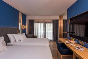 um quarto de hotel com duas camas e uma televisão em Barceló Tanger em Tânger