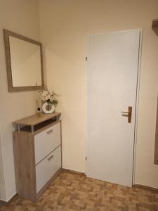 a room with a white door and a dresser and a mirror at Casa Lauda in Bad Vöslau in Bad Vöslau