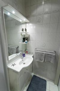 a white bathroom with a sink and a mirror at Casa Lauda in Bad Vöslau in Bad Vöslau