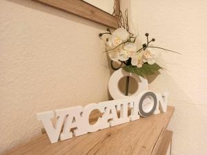 een vaas met bloemen op een plank met een bord bij Casa Lauda in Bad Vöslau in Bad Vöslau