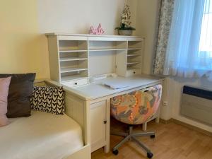 - un bureau avec une chaise à côté d'un lit et un bureau avec un ordinateur portable dans l'établissement Casa Lauda in Bad Vöslau, à Bad Vöslau